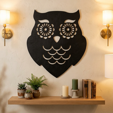 Black wooden owl wall art with white cutout details, shown against a plain white background.